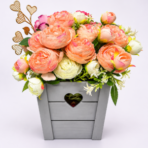 Aranjament floral decorativ cu bujori roz-piersică și flori crem, în ghiveci din lemn gri cu inimioară – Cadou elegant